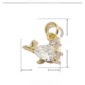 Detail view of a gold whale pendant with zircon inlays and technical dimensions
