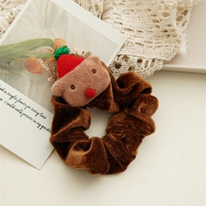Detail of a brown velvet Christmas scrunchie featuring a plush reindeer with a red hat