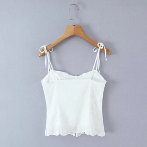 Close-up of white camisole with floral embroidery and adjustable lace-up straps