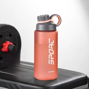 Close-up of 800ml matte red sport bottle with tea strainer on a gym bench