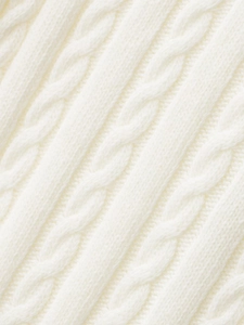 Macro shot of ivory cable knit texture showing premium wool blend fiber details