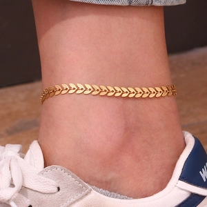 Detail showing a gold leaf anklet worn on the ankle with high-quality metal leaf texture