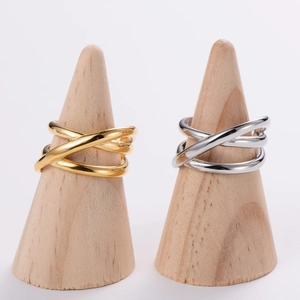 Detail of gold and silver crossover rings displayed on natural wooden cone stands