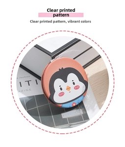 Detail of a portable round makeup mirror with a cute orange penguin pattern on it