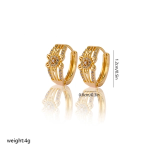 Detail of gold floral hoop earrings with zircon accents and hollow petal design