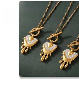 Detailed view of gold melting heart pendants with white rhinestones and OT buckle