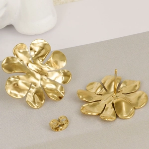 Detail view of gold flower earrings with brushed 18k gold finish and secure backings