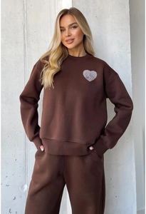 Detail shot of a dark brown tracksuit featuring a crewneck sweatshirt with heart print