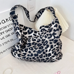 Detail showing high-capacity canvas crossbody bag with trendy black leopard print pattern