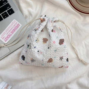 Close-up of cute cartoon dog pattern on a white seersucker drawstring storage bag