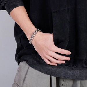 Close-up of punk style silver stainless steel bracelet with cross floral engraved links