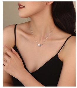 Detail of 925 sterling silver infinity heart pendant necklace on a female model