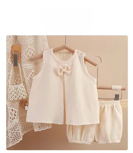 Détail de l'ensemble bébé crème en coton gaufré avec un joli nœud décoratif
