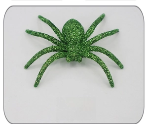 Close-up of green glitter plastic spider decoration for Halloween party prop decor