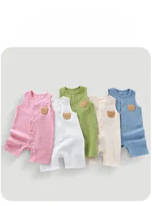 Flat lay of breathable cotton gauze baby rompers in five pastel colors with bear patches