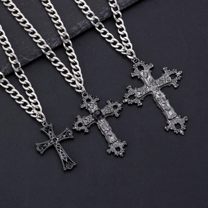 Detailed view of Gothic cross pendants with intricate floral texture and black gemstones