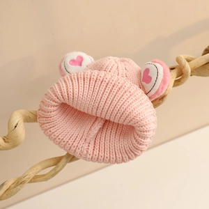 Détail du bonnet en tricot rose pour bébé avec oreilles de dessin animé et cœur