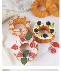 Realistische künstliche Donut-Modelle mit Sahne und Beeren auf einem Serviertablett