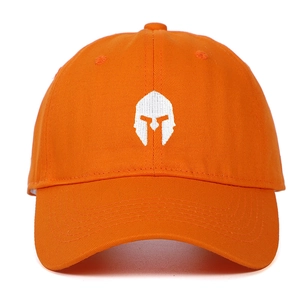 Detailed white embroidery of a Spartan helmet on a vibrant orange cotton baseball cap
