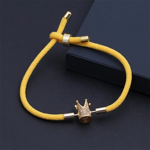 Vue détaillée du bracelet en corde tressée jaune avec breloque couronne dorée ajustable