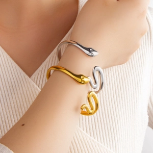 Minimalist 18k gold and silver plated snake-shaped open bracelet on model's wrist
