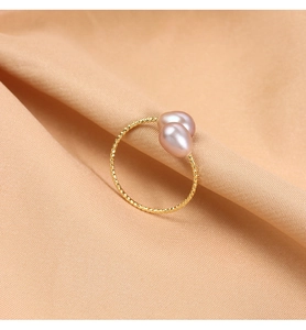 Macro shot of gold twist band ring featuring two drop-shaped pink freshwater pearls