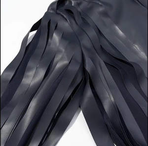 Close-up of black PU leather jacket featuring stylish fringe details and premium texture
