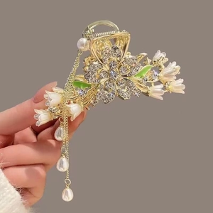 Detail view of flower hair claw clip with crystal petals and pearl tassel ornaments