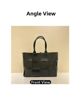 Front view of large black hand-woven leather tote bag with bright yellow lining