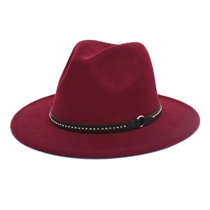 Detail of wine red fedora hat featuring a black leather band with golden metal rivets