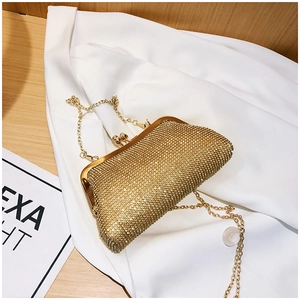 Macro detail of luxury gold evening clutch bag with sparkling rhinestones and metal clasp