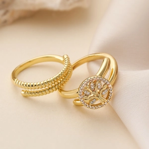 Gold plated tree of life ring set with sparkling zircon on elegant silk background