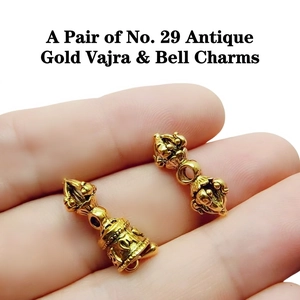 Close-up of antique gold Vajra and Bell pendants for DIY Buddhist jewelry making