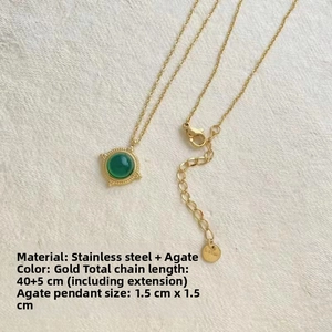 Détail du collier en acier inoxydable doré avec pendentif agate verte et fermoir mousqueton