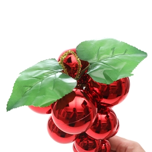Christmas red ball ornament with green faux leaves and golden ribbon for tree decoration