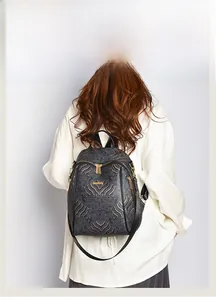 Detail of a chic Chinese style black backpack with gold cloud patterns and metallic zippers