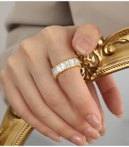 Detailed view of luxury gold-plated ring with rectangular zircon stones on hand