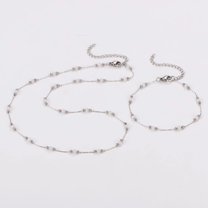 Detailed close-up of beaded choker and bracelet set with silver beads and lobster clasp