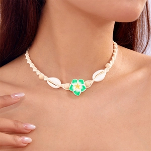 Bohemian woven shell necklace featuring a white plumeria flower pendant on a female neck