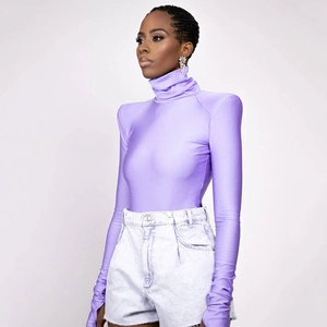 Detail view of purple high-neck slim top with long sleeves and light-colored denim shorts