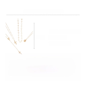 Detail view of gold multilayer necklace featuring cross, portrait coin, and pearls