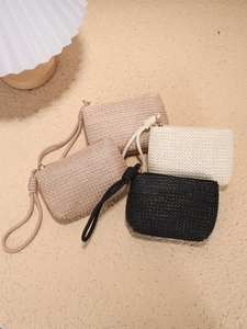 Straw woven coin purse collection in beige and black with knotted wrist straps