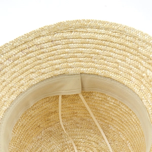 Internal view of straw sun hat showing adjustable drawstring and fine woven texture