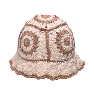 Detail of crochet floral pattern on a beige and brown knit bucket hat for women
