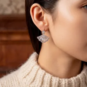 Sparkling fan-shaped zircon pendant earrings on a model with minimalist silver finish
