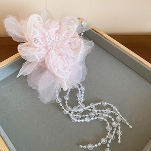 Detail von rosa Organza-Blumen-Haarspange mit Pailletten und hängenden Perlen-Quasten