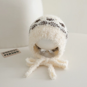 Detail of warm plush winter hat featuring ethnic jacquard pattern and soft earflap straps