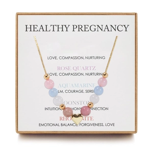 Macro view of pregnancy healing stones necklace with rose quartz and heart charm