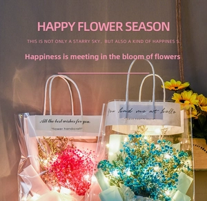 Close-up of Gypsophila bouquets in PVC gift bags with warm LED string lights