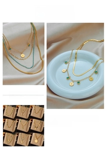 Detailed macro view of layered 18K gold stainless steel necklaces with coin pendants